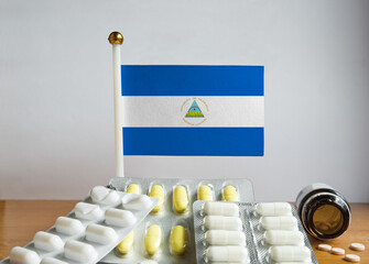 Flag of Nicaragua with Pills and Capsules. Pharmaceutical Concept
