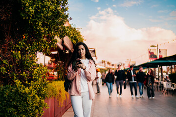 Focused woman walks through city street while texting, embracing digital mobility, personal rhythm...
