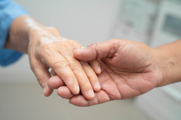 Caregiver holding hands Asian elderly woman patient, help and care in hospital.