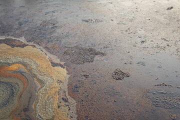 Contaminated sewage dirty fluid mix with chemical or crude oil, it floating on water surface at public water place. Environmental issue from industrial. Close-up