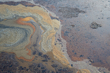 Contaminated sewage dirty fluid mix with chemical or crude oil, it floating on water surface at public water place. Environmental issue from industrial. Close-up