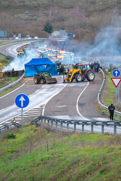 Tractors and smoke blocking a road in Spain the concept of an agricultural strike