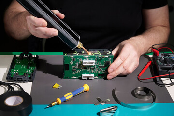 Close-up a man spot welds a battery assembly.