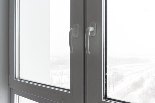 pair of white PVC windows with sleek, ergonomic handles. The frosted glass panels offer privacy while letting in natural light. The frames are smooth, modern, and tightly sealed.