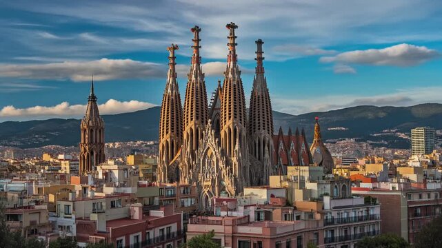 Sagrada Familia basilica in Barcelona Spain with intricate Gothic architecture and surrounding cityscape under a cloudy blue sky