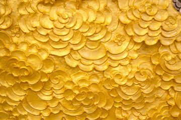 Gold-painted wall art in a Thai temple