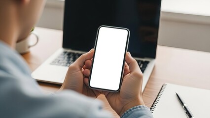 Person holding smartphone with blank screen at desk with laptop and notebook social media thumbnail poster banner download 2026 2027