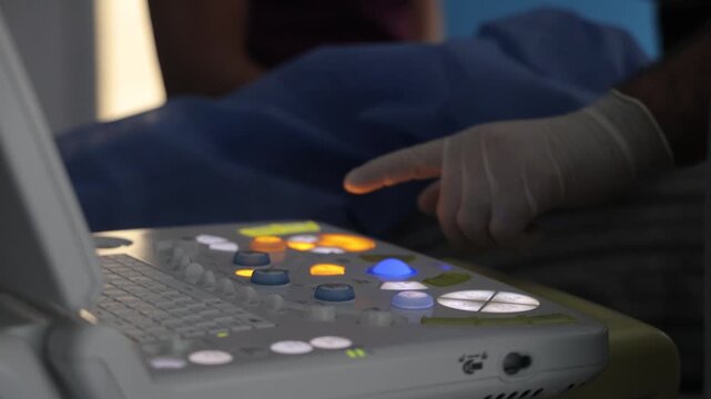 Close-up video of a doctor&rsquo;s hand interacting with a medical device, pressing buttons and adjusting settings. The scene takes place in a clinical or hospital environment. Useful for healthcare content
