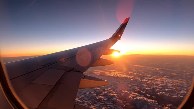Airplane wing at sunset from window