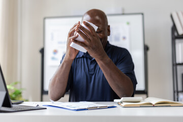 Senior businessman tearing document at office desk after reading bad news.