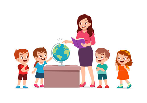 Smiling female teacher showing happy young children the world on a globe while holding a book in a bright classroom