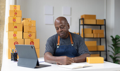 Stressed mature small business owner looking at tablet with concerned expression.