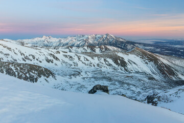 View of snow-dusted mountain peaks kissed by the pastel hues of dawn, a serene winter panorama unfolds in Nizna Bystra, Zilina Region, Slovakia.