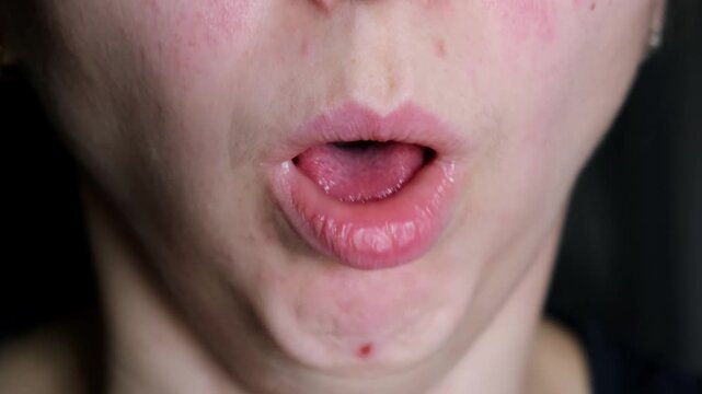 Close-up of a coughing mouth of a female face. A woman has a coughing fit. Pneumonia or tuberculosis. The concept of lung disease. Bronchial asthma. High quality 4k footage,