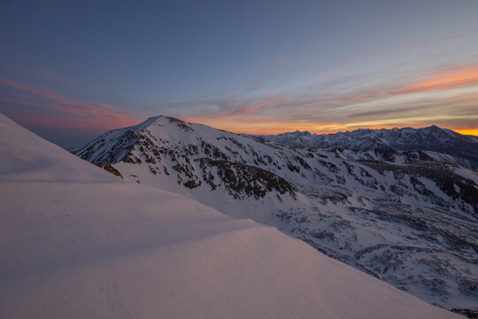 View of snow-covered mountains under a sky brushed with hues of pink and orange, where the crisp air bites and the landscape whispers tales of winter's embrace, Nizna Bystra, Zilina Region, Slovakia.