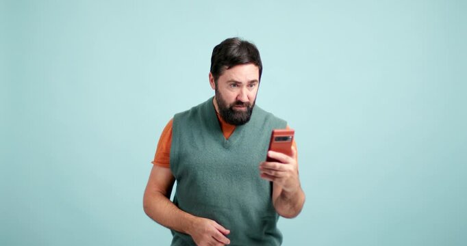 Confused bearded man looking at his smartphone