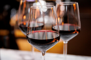 Close-up of red wine glasses with warm reflections