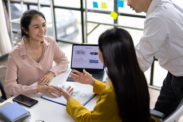 Team Meeting Analyzing Financial Reports. Collaborative meeting, analyzing financial reports on a laptop. Charts and graphs displayed, indicating on data-driven decision-making in office.