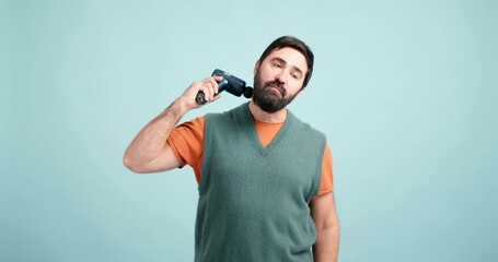Bearded man using percussion massage gun for neck pain relief
