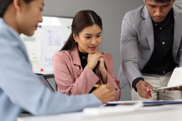 Obraz premium Business team discussing and brainstorming, sharing ideas, working together during a meeting in the office, using data reports and paperwork to analyze and plan marketing and financial strategies.