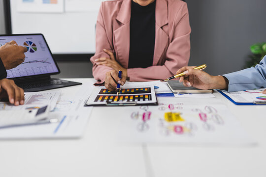 Business people working together analyzing financial charts and graphs using calculator and tablet during a meeting discussing company financial strategy. - Powered by Adobe