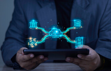 Businessman holding tablet displaying Cloud Sync hologram connecting banking, analytic reports, currency, and database. Concept of fintech and real-time data synchronization.