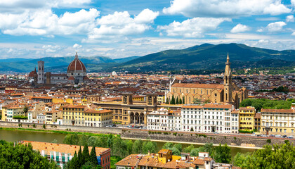 Panoramic view of Florence (Firenze), Italy, showing rooftops, landmarks like Palazzo Vecchio and Santa Maria del Fiore with its red dome, and hills with forests on a sunny summer day.
