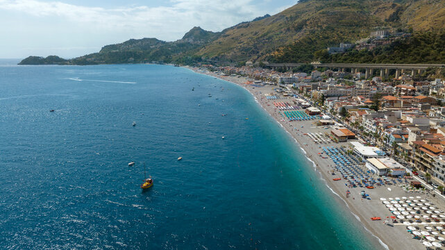 Aerial view of the small town of Letojanni, in province of Messina, Sicily, Italy. It is a Sicilian coastal town and a beautiful tourist destination. A long pebble beach stretches towards the horizon.