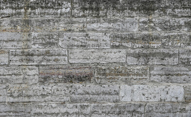 textured, discolored concrete wall displaying a distressed and aged appearance with prominent vertical streaks of darker and lighter tones. Represent grungy textures, weathered surfaces, backgrounds