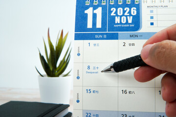 Close up hand holding pen pointing at Deepavali on calendar. Concept of Festival of Lights,...