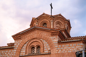 Architectural detail of the Saint Panteleimon church domes in Ohrid, featuring traditional Byzantine brickwork and stone under a dramatic sky.