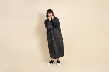 20s Asian woman wearing raincoat