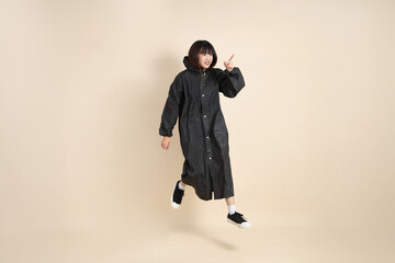 20s Asian woman wearing raincoat