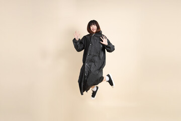 20s Asian woman wearing raincoat