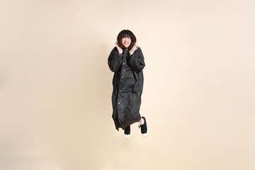 20s Asian woman wearing raincoat