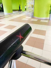 School turnstile access control system with red indicator light, showcasing security features in a vibrant interior space, emphasizing safety and monitoring concept