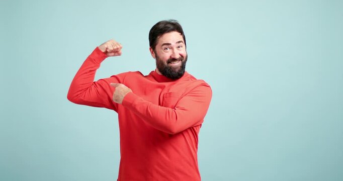 Strong bearded man showing biceps and muscles
