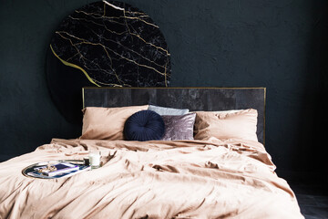 Cozy bedroom featuring a stylish bed with soft beige linens, decorative pillows, and a modern round wall art piece, creating a serene and inviting atmosphere for relaxation