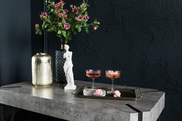 Elegant tabletop arrangement featuring a floral centerpiece, decorative vase, and two cocktails on a stylish tray, creating a sophisticated ambiance for gatherings and celebrations