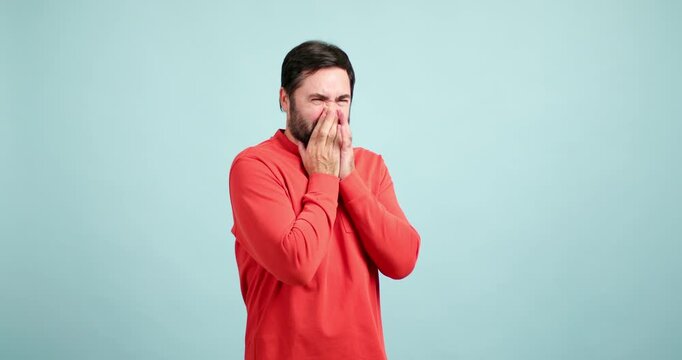 Disgusted bearded man smelling something bad