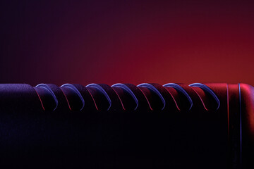 The surface shows intricate patterns highlighted by artistic lighting. The background has colors that create a contrast. The focus is on details of the material.