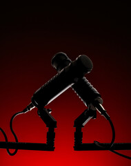 Two microphones are positioned on a stand with a red background. They are ready for use in a recording session. The setup indicates a professional environment focused on sound.