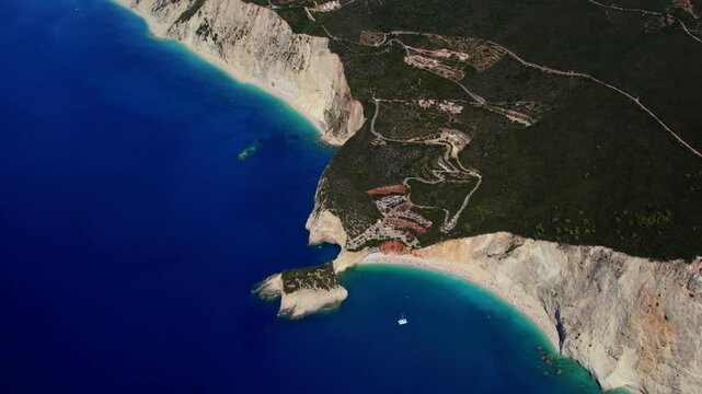 Aerial view of the rugged coastline where the sapphire sea meets the stark white cliffs and verdant forests, Lefkada Island, Lefkada, Greece.
