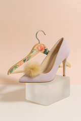 Elegant red high heel shoe with white fur lining on clear stand
