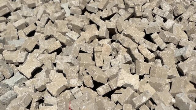 Pile of gray bricks stacked outdoors for construction backgrounds and industrial projects