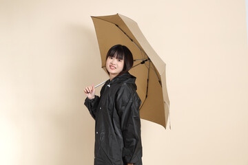 20s Asian woman wearing raincoat