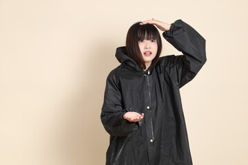 20s Asian woman wearing raincoat