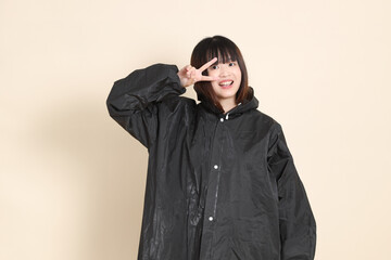 20s Asian woman wearing raincoat