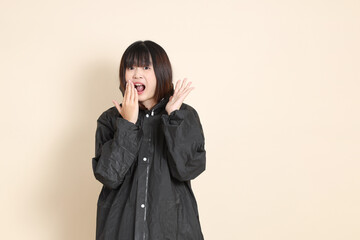 20s Asian woman wearing raincoat