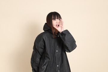 20s Asian woman wearing raincoat